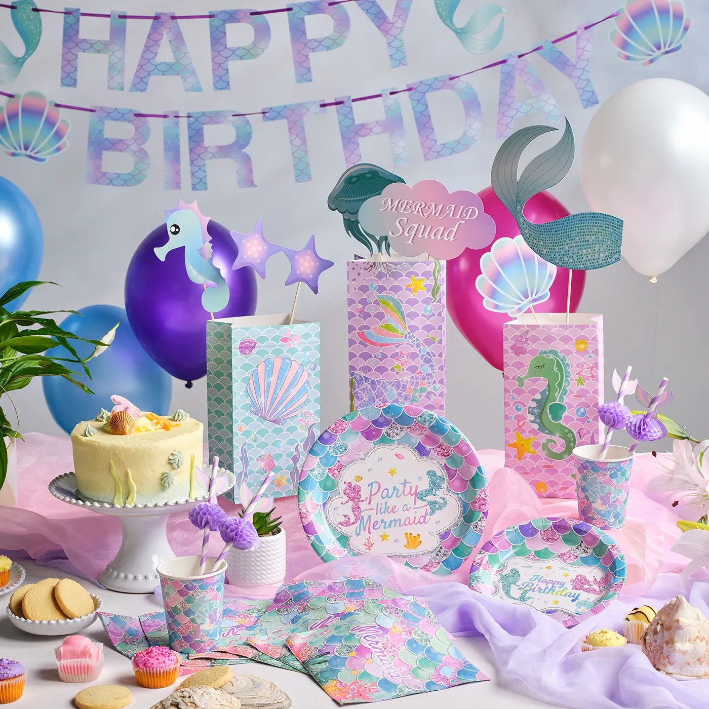 Mermaid-themed birthday kids party setup with cake, balloons, and decorations.